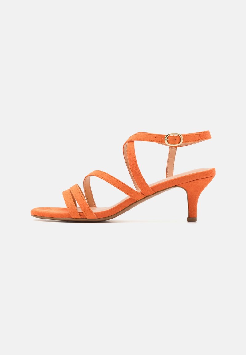 Sandale orange en daim à brides, petit talon kitten et bride à boucle dorée à la cheville, vue latérale sur fond blanc.