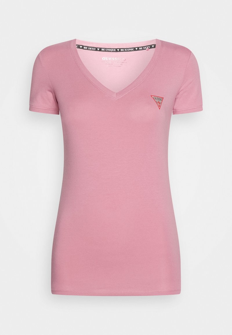 T-shirt ajusté rose pour femme avec col en V, manches courtes et petit logo rouge Guess sur la poitrine gauche.