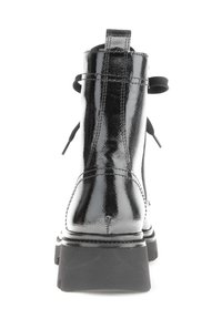 Black patent leather ankle boots with a smooth, shiny surface, rear pull tab, and thick black rubber sole. Features double stitching detail.