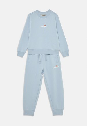 Lyseblå hettegenser og matchende joggebukser laget av mykt materiale. Hettegenseren har en rund halslinning og logo. Joggebuksene har elastisk livlinje.