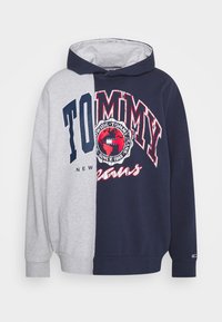 Hettegenser med halv grå og halv marineblå design, med trykt "TOMMY" tekst og globusgrafikk i rødt og hvitt. Blandingsmateriale av bomull.
