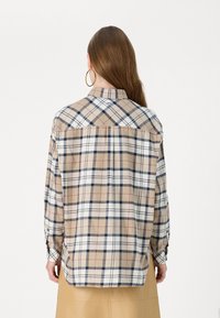 Plaid shirt in beige, white, and navy with long sleeves, buttoned cuffs, and a back yoke design. Soft texture, relaxed fit.