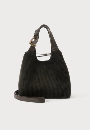 Sac à main en tissu côtelé noir avec poignées en cuir marron foncé, ferrures en laiton et bandoulière amovible sur un fond clair uni.