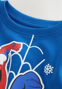 Collo del sudore blu con braccio di Spiderman stampato e design della ragnatela bianca sul tessuto.