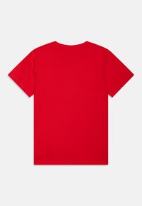 Camiseta de algodón roja con un cuello clásico y mangas cortas. Textura suave; sin gráficos ni patrones. Diseño simple y minimalista.