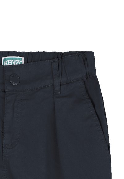 Navyblauwe broek in close-up, met een gladde textuur, elastische tailleband, voorzakken en een knoopdetail bij de tailleband.