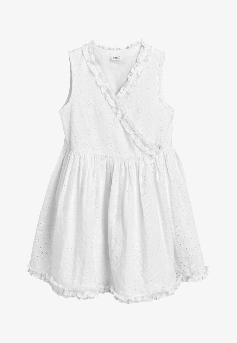 Robe bébé blanche sans manches avec motif floral ajouré, bordure à volants le long du décolleté en V et de l'ourlet, taille froncée et devant croisé avec bouton.