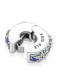 Srebrna sponka s ukrivljeno obliko, okrašena z modrimi in svetlo modrimi kamni ter graviranimi oznakami. Teksturne akcenti obogatijo oblikovanje.