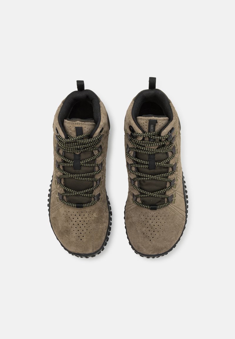 Bruine suede wandelschoenen met zwarte accenten, voorzien van gestructureerde veters in groen en zwart, perforaties op de neus en een robuuste zool.