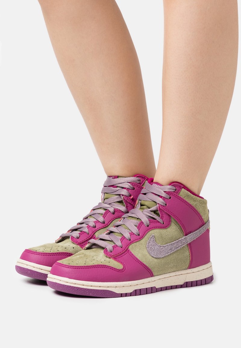 Sneakers Nike w stylu wysokim charakteryzują się połączeniem różowej skóry i oliwkowego zamszu, z szarymi akcentami, fakturowanymi sznurówkami i wyściełaną podeszwą.