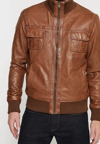 Brown leather jacket with a zip front, ribbed collar, and two chest pockets. Features a smooth texture and fitted ribbed cuffs and hem.