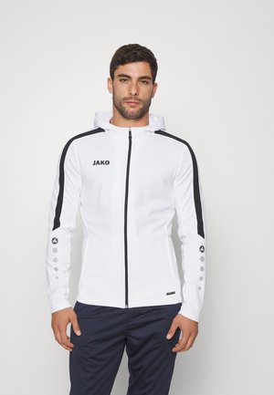 Veste de sport blanche avec fermeture éclair à l'avant, capuche, rayures noires sur les côtés et accents circulaires gris sur les manches. Logo de la marque positionné sur la poitrine.