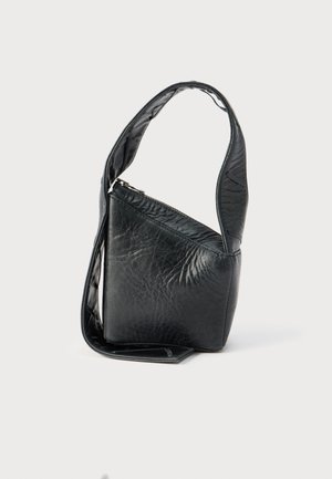 Μικρό μαύρο δερμάτινο τσαντάκι με ένα φαρδύ λουράκι και φερμουάρ στην κορυφή, όρθιο σε απλό λευκό φόντο.