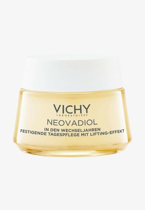 Vichy Neovadiol cream in a round glass jar with a white lid. The jar has a smooth, glossy finish and is filled with light yellow cream.