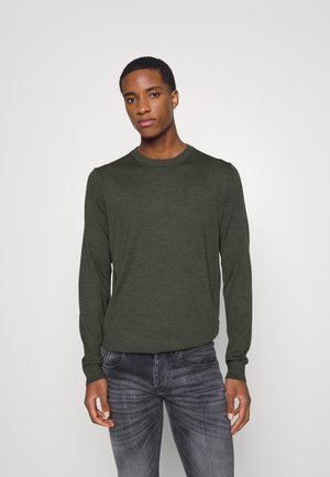 Suéter verde de manga larga hecho de material suave, con un cuello redondo y un diseño ajustado, combinado con jeans gris claro de pernera ajustada.