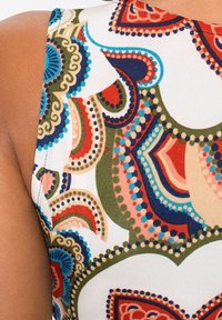 Barevná látka se vzorem točivých tvarů v červené, modré, zelené a béžové na bílém pozadí, s hladkou texturou a přiléhavým střihem.