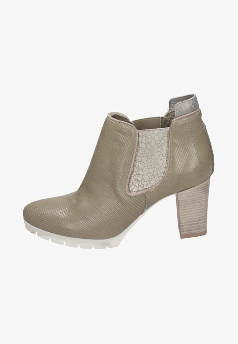 Bottine beige avec un dessus texturé, des panneaux latéraux élastiques, un talon à motifs et une semelle en caoutchouc blanche.