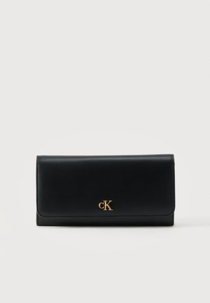 Czarny skórzany portfel z złotym logo CK umieszczonym na środku przedniej klapki, o prostokątnym kształcie na jednolitym jasnym tle.