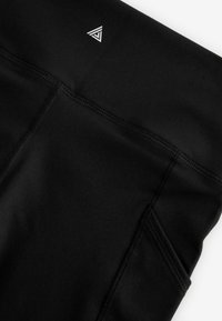 Svarta träningsleggings i ett mjukt och stretchigt material, med en diskret logotyp i det övre hörnet och platta sömmar.