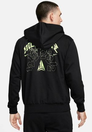 Black hoodie featuring a large graphic on the back in neon green, with various stylized numbers and letters, made of soft fabric with a standard fit.