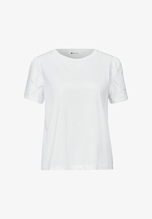 Camiseta blanca de manga corta con cuello redondo y mangas con patrón de encaje, mostrada sobre un fondo liso.