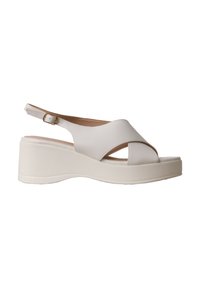 Sandale compensée blanche avec brides croisées et boucle de cheville réglable, bout ouvert et semelle matelassée pour le confort.