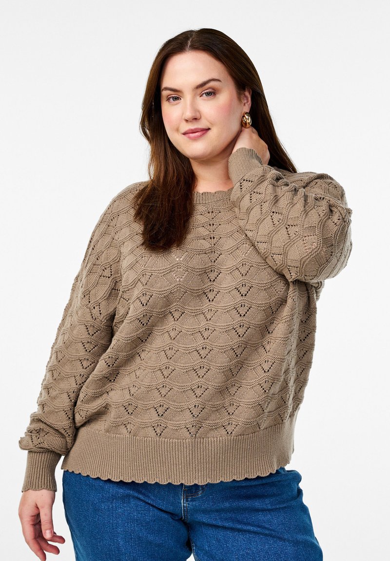 Light brown knitted sweater with a textured, geometric pattern and ribbed hem. Rounded neckline and slightly puffed sleeves.