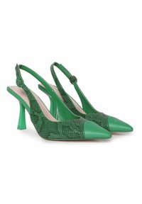 Tacones verdes tipo slingback con punta afilada. Tejido de imitación de serpiente texturizado en la parte superior y puntera de cuero suave. Tacón de aguja.
