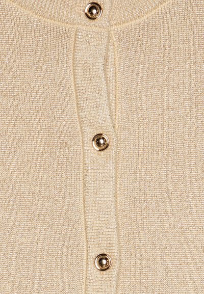 Beige gestrickte Strickjacke mit weicher Textur, ausgestattet mit goldfarbenen Knöpfen und einem gerippten Kragen sowie einer Knopfleiste, die ein dezentes Schimmern zeigt.