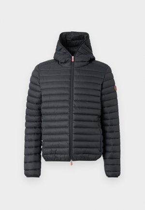 Puff jakke i svart nylon med horisontale sømmer, glidelås og fasthette. Har en liten rød glidelåsholder og logoemblem.