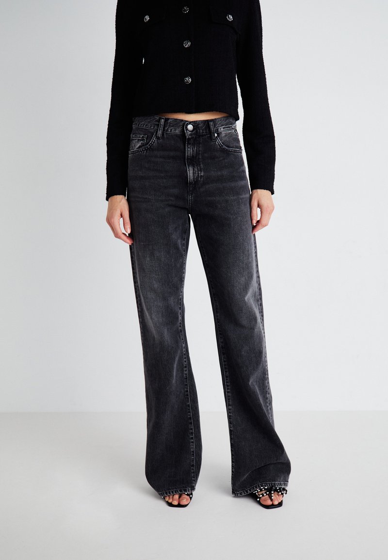 High-waisted, wide-leg black jeans in soft, slightly distressed denim with a subtle wash. Features front pockets and a standard button closure.
