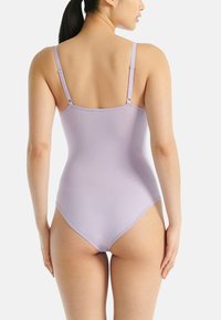 Fialový body s nastavovacími popruhy, hladkou texturou, přiléhavým střihem a vysokým výkrojem, který předvádí minimalistickou zadní část.