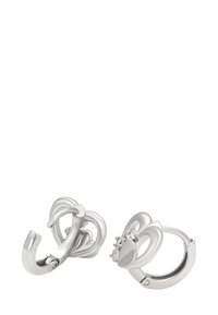 Sudraba auskari ķēdīšu formā, kas izskatās kā sirdis, ar maziem caurspīdīgiem akmeņiem uz baltas fona.