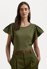 Maglietta verde oliva con maniche corte e arricciate e scollatura rotonda, abbinata a pantaloni su misura a vita alta e una cintura marrone con fibbia a logo.