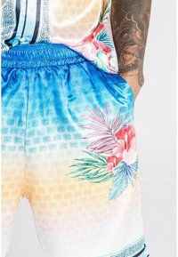 Shorts med en gradient fra blå til fersken, med tropiske blomster mønstre i pink og grøn, samt en elastisk talje for komfort.