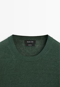 Dunkelgrüner Leinenpullover mit Rundhalsausschnitt, geripptem Kragen und Massimo Dutti Etikett, das innen am Kragen eingenäht ist.