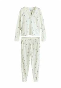 Lyst farvet, hyggeligt pyjamasæt med en V-hals top og bukser i joggingstil. Har et legende skisportsmønster i blå og rød på en cremefarvet baggrund.