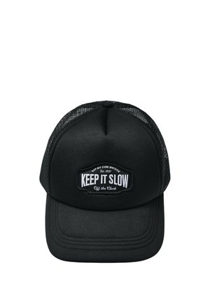 Schwarze Trucker-Cap mit Netzrücken und einem Patch auf der Vorderseite mit der Aufschrift „Keep It Slow, Off the Clock, Est. 1991, Day-Off Club Division.“