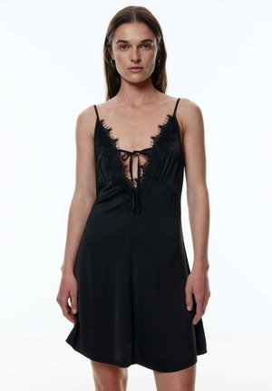 Schlafkleid aus schwarzem Satin mit Spitzenborte und tiefem V-Ausschnitt. Mit verstellbaren Trägern und einer Bindung vorne für eine figurbetonte Passform.