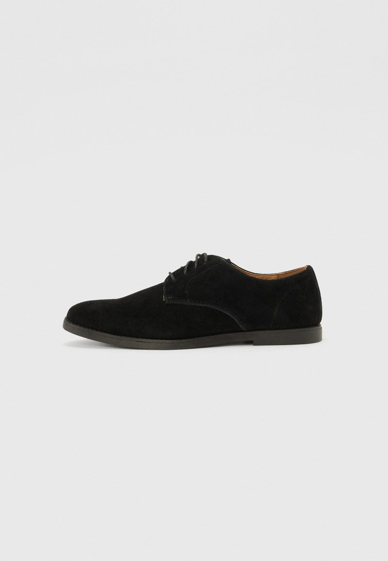 Black suede lace-up shoe with a rounded toe, smooth surface, and minimalistic design. Features a flat rubber sole.