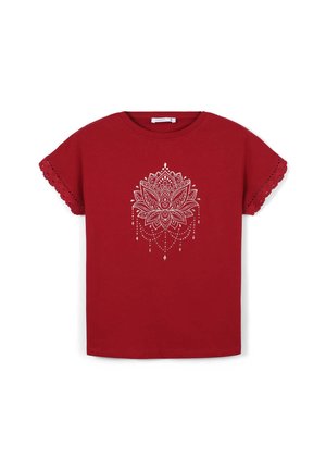 Maglietta in cotone rosso a maniche corte con un design di mandala bianco con accenti pendenti e bordi a onda sulle maniche.