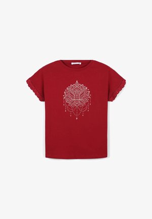 Maglietta in cotone rosso a maniche corte con un design di mandala bianco con accenti pendenti e bordi a onda sulle maniche.