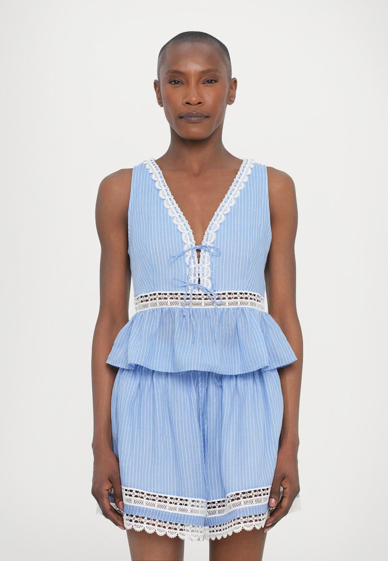 Romper a righe azzurro chiaro con vita a peplum, scollatura a V profonda, bordo in pizzo e nodo regolabile. Tessuto morbido, vestibilità comoda e orlo dettagliato.