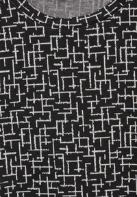 Schwarzer Stoff mit einem geometrischen Muster in Weiß. Die Textur wirkt weich und gestrickt, mit einem runden Ausschnitt.