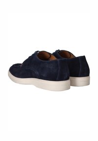 Marineblauwe suède schoenen met een gladde textuur, witte rubberen zool en een laag profiel ontwerp. Beschikken over een ronde neus en subtiele branding op de hak.