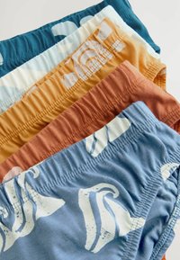 Farverige badeshorts i en stablet arrangement. Funktioner inkluderer elastiske taljebånd, forskellige geometriske mønstre og teksturer i blå, orange og creme.