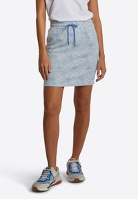 Světle modrá mini sukně s geometrickým vzorem, elastickým pasem a šňůrkou. V kombinaci se šedými a modrými sportovními teniskami.