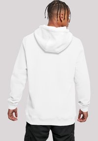 Sudadera blanca con capucha amplia, puños y bajo de canalé. Textura de tela suave; vista trasera que muestra un detalle mínimo y sin gráficos.