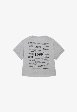 T-shirt gris à manches courtes présentant diverses traductions du mot "amour" dans différentes polices et langues imprimées au dos.