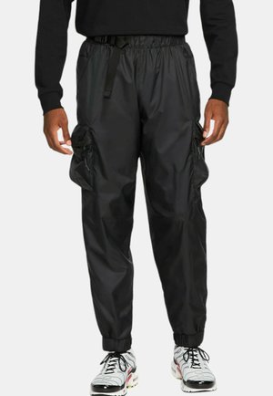 Black, lightweight, nylon cargo pants with elastic cuffs and waist. Features two side pockets and adjustable belt. Smooth texture.